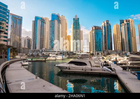 Wunderschöne Aussicht auf die teuren Yachten und Motorboote, die an den Piers der Dubai Marina festgemacht sind, umgeben von hohen Wolkenkratzern, Dubai, VAE Stockfoto