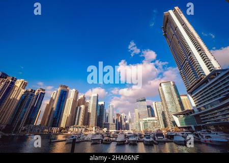 Wunderschöne Aussicht auf die teuren Yachten und Motorboote, die an den Piers der Dubai Marina festgemacht sind, umgeben von hohen Wolkenkratzern, Dubai, VAE Stockfoto