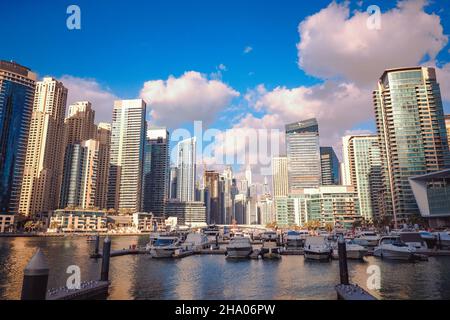 Wunderschöne Aussicht auf die teuren Yachten und Motorboote, die an den Piers der Dubai Marina festgemacht sind, umgeben von hohen Wolkenkratzern, Dubai, VAE Stockfoto