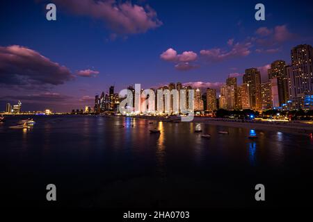 Panoramablick auf die Skyline des Dubai Marina Viertels mit seinen hohen Wolkenkratzern, die sich neben dem Strand und der Uferpromenade, Dubai, VAE, erheben Stockfoto