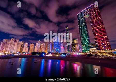 Panoramablick auf die Skyline des Dubai Marina Viertels mit seinen hohen Wolkenkratzern, die sich neben dem Strand und der Uferpromenade, Dubai, VAE, erheben Stockfoto