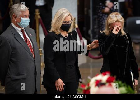 Liz Cheney (Republikaner von Wyoming), Vertreterin der Vereinigten Staaten, Mitte, Und die US-Vertreterin Debbie Dingell (Demokratin von Michigan), rechts, wird emotional, während sie dem ehemaligen Senator Robert J. Dole (R-KS) ihren Respekt zollt, da er am Donnerstag, dem 9. Dezember 2021, in der Rotunde des US-Kapitols in Washington, DC, im Staat liegt. Kredit: Sarahbeth Maney/Pool über CNP /MediaPunch Stockfoto