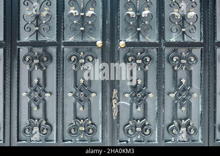 Schwarze schmiedeeiserne Türen mit goldenen Ornamenten Stockfoto