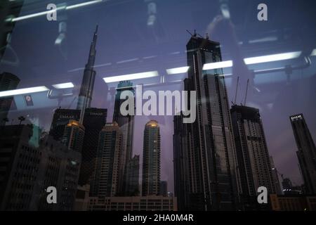 Dubai, Vereinigte Arabische Emirate. 6th. November 2021. Ein Blick auf den Burj Khalifa und andere Wolkenkratzer mit einem Spiegelbild der Metro-Pendler. (Bild: © Omar Marques/SOPA Images via ZUMA Press Wire) Stockfoto