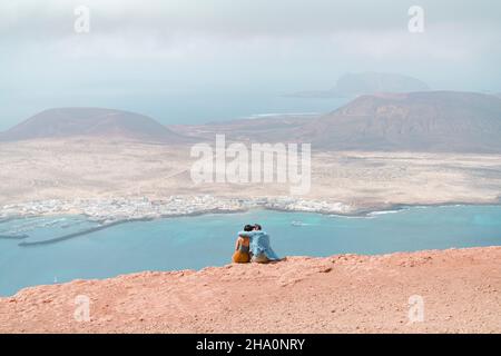 Ein Paar, das sich auf einer Klippe im Mirador del Rio, Lanzarote, entspannt. Stockfoto