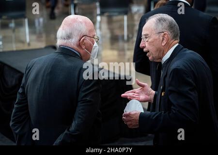 Washington, DC. 09th Dez 2021. Der Senator der Vereinigten Staaten, Patrick Leahy (Demokrat von Vermont), spricht mit dem US-Senator Chuck Grassley (Republikaner von Iowa), bevor der Sarg des ehemaligen US-Senators Bob Dole (Republikaner von Kansas) in der Rotunde des US-Kapitolgebäudes eintrifft, wo er am Donnerstag im Bundesstaat auf dem Capitol Hill liegen wird, 09. Dezember 2021 in Washington, DC. Quelle: Jabin Botsford/Pool via CNP/dpa/Alamy Live News Stockfoto