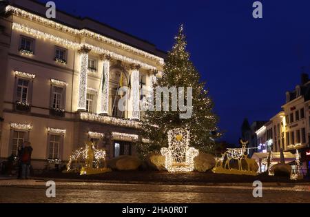 AALST, BELGIEN, 5. DEZEMBER 2021: Blick auf den Hauptplatz während der Weihnachtszeit, mit einem Weihnachtsbaum und dem beleuchteten alten Rathaus in Aalst. Stockfoto