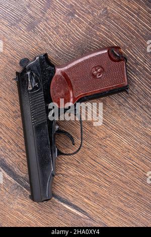 Draufsicht auf die alte Pistole des makarov-Systems auf einem Holzhintergrund. Nahaufnahme. Stockfoto