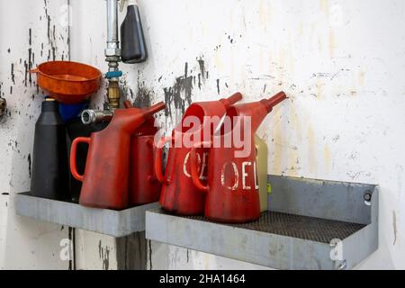 In einer Autowerkstatt befinden sich mehrere rote Öldosen Stockfoto