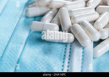 Medizinische Behandlungspillen auf hygienischen Schutzmasken aus der Nähe. Makro. Orale Medizin gegen Coronavirus Stockfoto