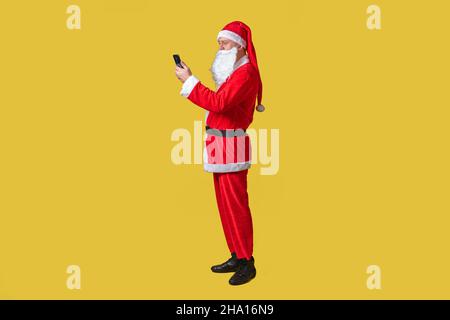 weihnachtsmann gelb funky groß, Urlaub weihnachten Spaß glücklich. Rot reif, feiern Sie mit dem Telefon in der Hand Stockfoto