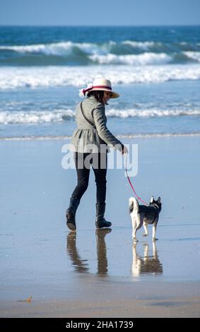 Eine 46-jährige Frau, Christina Sandoval, spaziert mit Mieka, dem Hund des Fotografen, am Tijuana Beach, Tijuana, Mexiko. Stockfoto