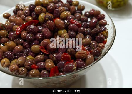 Eine Glasschüssel mit zerkleinerten Oliven, gewürzt mit Öl und Chili Stockfoto