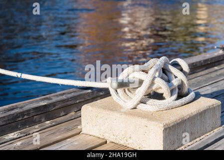 Nahaufnahme eines an einen Strang geknüpften Festzeltes an einem hölzernen Pier an einem sonnigen Herbsttag Stockfoto