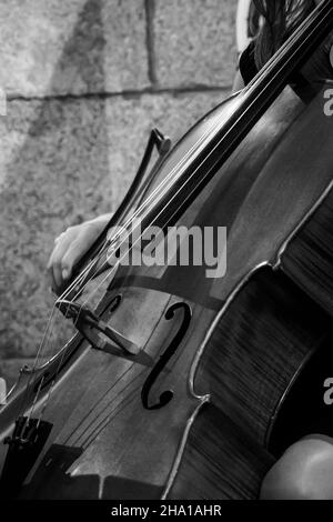 Elegante Frau, die in einer schwarz-weißen Kirche Bass spielt Stockfoto