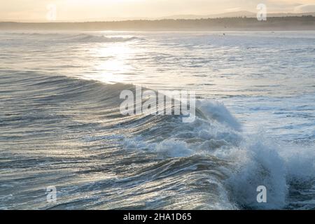 LOSSIEMOUTH, MORAY, SCHOTTLAND - 9. DEZEMBER 2021: Dies ist eine Szene am östlichen Strandbereich des Hafens mit Wellen kurz nach Sonnenaufgang in Lossiemouth, Mo Stockfoto