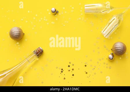 Rahmen aus Champagnerflasche, Gläsern, Dekorationen und goldenem Konfetti auf farbigem Hintergrund Stockfoto