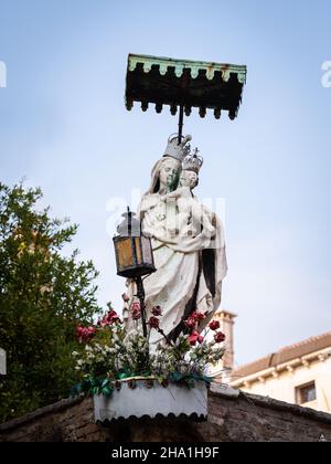 Status der heiligen maria und Kind in Venedig (Italien), im Freien an der Ecke einer Backsteinmauer Stockfoto