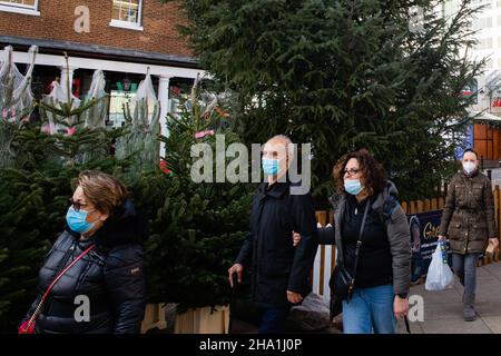 Uxbridge, Großbritannien. 9th. Dezember 2021. Im Wahlkreis von Premierminister Boris Johnson laufen die Käufer mit Gesichtsbezügen an Weihnachtsbäumen vorbei, um sie zu verkaufen. Ab Freitag, dem 10th. Dezember, sind Gesichtsbedeckungen für die meisten öffentlichen Hallen, einschließlich Theater, Kinos und Kultstätten, sowie für den öffentlichen Nahverkehr und an Orten wie Geschäften und Friseuren obligatorisch. Kredit: Mark Kerrison/Alamy Live Nachrichten Stockfoto