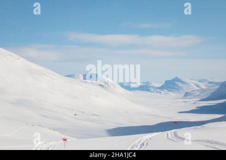 Kungsleden Trail führt ins Tal in Richtung Salka Hütte, Wintersaison, Lappland, Schweden Stockfoto