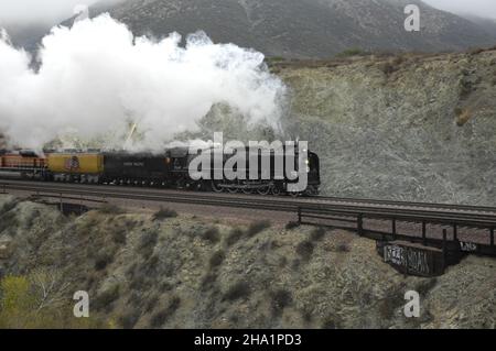 Union Pacific 844 zieht am Caschon Pass bei Blue Cut in San Bernardino, Kalifornien, vorbei, nachdem er durch Devore gezogen ist. Stockfoto