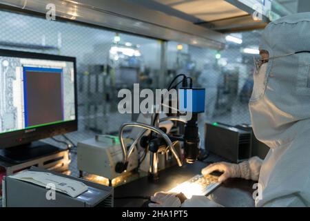 HEFEI, CHINA - 1. DEZEMBER 2021 - Technische Mitarbeiter produzieren und untersuchen ein Kameramodul für Mobiltelefone in einer staubfreien Werkstatt in Hefei, Provinz Anhui, Stockfoto