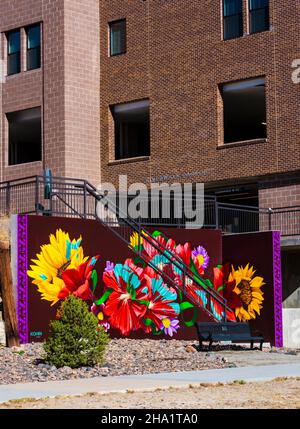 Bunte Blumen von Wandgemälden im Freien, die vom Künstler Dan Toro auf einer Treppe in der Nähe des Parkplatzes am River Walk in der Innenstadt von Castle Rock Colorado USA geschaffen wurden. Stockfoto