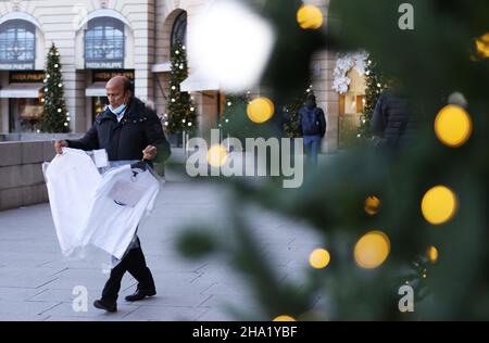 Paris, Frankreich. 9th Dez 2021. Ein Mann, der Wäschereien hält, geht am Vendome Place in Paris, Frankreich, am 9. Dezember 2021 an einem riesigen Weihnachtsbaum vorbei. Frankreich verzeichnete am Mittwoch einen neuen täglichen Infektionsrekord seit dem 2020. November mit 61.340 neuen COVID-19-Fällen, die in den letzten 24 Stunden bestätigt wurden. Damit steigt die Gesamtzahl der COVID-19-Fälle in dem Land auf 8.048.931. Kredit: Gao Jing/Xinhua/Alamy Live Nachrichten Stockfoto