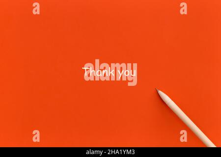 Stift auf rotem Hintergrund mit den Worten Danke. Draufsicht. Flach liegend. Stockfoto