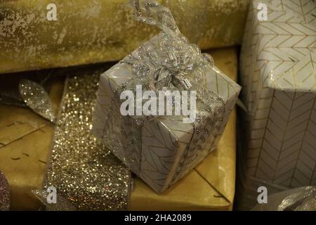 Wunderschön gepackte Schachtel mit silbernen Bändern unter dem Weihnachtsbaum Stockfoto
