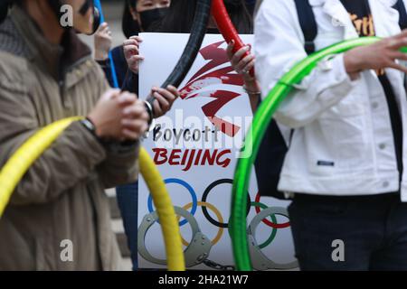 Taipei, Taipei, Taiwan. 10th Dez 2021. Die Demonstranten werden an die Olympischen Ringe gefesselt, wobei eines ein Plakat mit der Aufschrift Boykott Beijing hält, während eines Protestes zur Boykottierung der Winterspiele 2022 in Peking vor der Bank of China (Zweigstelle Taipei). Die Vereinigten Staaten, Kanada, Großbritannien und Australien haben zugesagt, nach dem Verschwinden des chinesischen Tennisspielers Peng Shuai und den Menschenrechtsverletzungen gegen Hongkong und Xinjiang keine Beamten zur Teilnahme an den Spielen zu entsenden, um China zu boykottieren. (Bild: © Daniel Ceng Shou-Yi/ZUMA Press Wire) Stockfoto