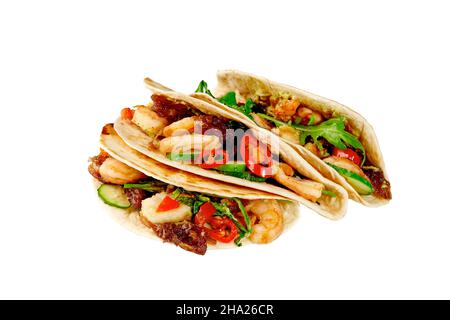 Tacos mit Garnelen, Guacamole, Salsa Pico de gallo, karamellisierten Zwiebeln, Gurke, Rucola und Chili isoliert auf Weiß Stockfoto