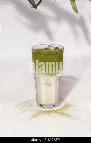 Glas vereisten Kokosnuss Matcha Latte auf weißem Hintergrund Stockfoto