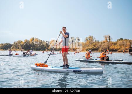 22. August 2021, Ufa, Russland: Gruppe von Menschen haben Spaß und schwimmen auf den beliebten sap-Boards auf einem Fluss Stockfoto