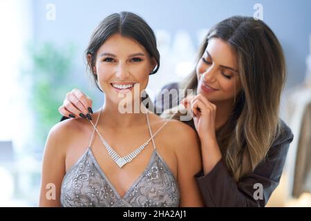 Frau, die Kleidung und Halskette mit einem Begleiter versucht Stockfoto