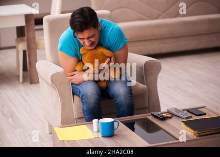 Junger Mann und Bär Spielzeug zu Hause Stockfoto