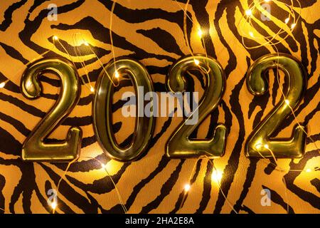 Nummer 2022 auf Tiger-Tuch mit leuchtender Girlande, flaches Lay. Symbol 2022 Tiger Stockfoto