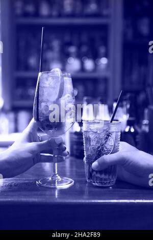 Frau und Mann Anheben einer Brille von Cocktails in der Bar Hintergrund Stockfoto