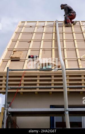 Haus- und Dachisolierung, Außenwandisoliersystem. Dachdecker spezialisiert auf lose Holzfaserwolle STEICO Zell, eine ökologische, atmungsaktive, Anti-A Stockfoto