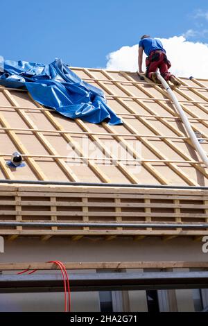 Haus- und Dachisolierung, Außenwandisoliersystem. Dachdecker spezialisiert auf lose Holzfaserwolle STEICO Zell, eine ökologische, atmungsaktive, Anti-A Stockfoto