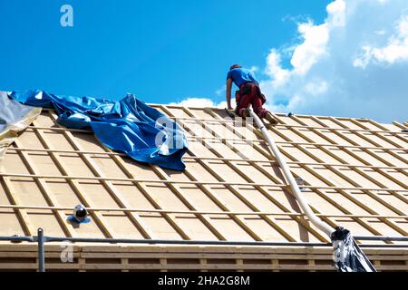 Haus- und Dachisolierung, Außenwandisoliersystem. Dachdecker spezialisiert auf lose Holzfaserwolle STEICO Zell, eine ökologische, atmungsaktive, Anti-A Stockfoto