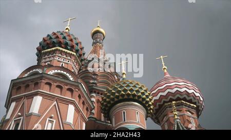 Blick von unten auf die Basilius-Kathedrale mit bunten Kuppeln und goldenen Kreuzen, die im Zentrum Moskaus auf dem Roten Platz stehen. Russische la Stockfoto