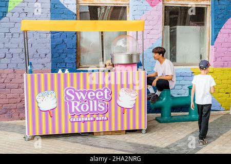 18. August 2021, Ufa, Russland: Süße Brötchen und Zuckerwatte werden an einem Streetfood-Kiosk verkauft. Kinder Desserts als ein Geschäft in Fast Food Stockfoto