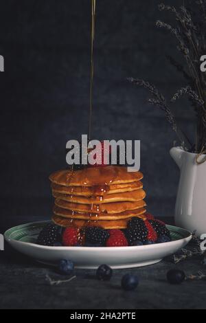 Vertikale Aufnahme eines köstlichen Frühstücks mit Pfannkuchen und Beeren Stockfoto