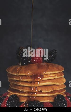 Vertikale Aufnahme eines köstlichen Frühstücks mit Pfannkuchen und Beeren Stockfoto