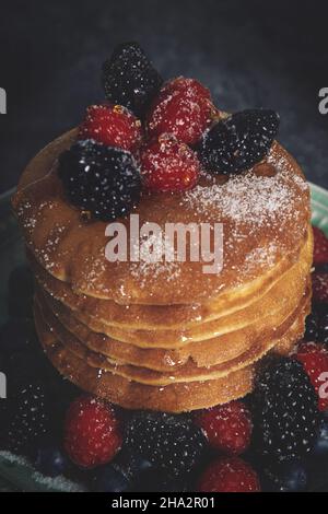 Vertikale Aufnahme eines köstlichen Frühstücks mit Pfannkuchen und Beeren Stockfoto
