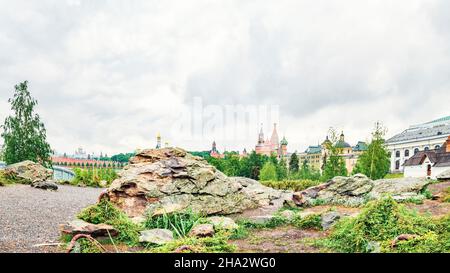 Riesiger Stein, Gras und Flechten im Zentrum von Moskau im Zaryadye Park vor dem Hintergrund der Basilius-Kathedrale Stockfoto