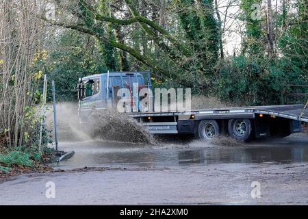 Station Lane, Godalming. 10th. Dezember 2021. Starke Regenfälle über Nacht verursachten Probleme mit Oberflächenüberflutungen in den Heimatkreisen. Fahrzeuge, die durch das Hochwasser in Godalming in Surrey fahren. Kredit: james jagger/Alamy Live Nachrichten Stockfoto