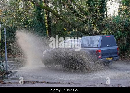 Station Lane, Godalming. 10th. Dezember 2021. Starke Regenfälle über Nacht verursachten Probleme mit Oberflächenüberflutungen in den Heimatkreisen. Fahrzeuge, die durch das Hochwasser in Godalming in Surrey fahren. Kredit: james jagger/Alamy Live Nachrichten Stockfoto