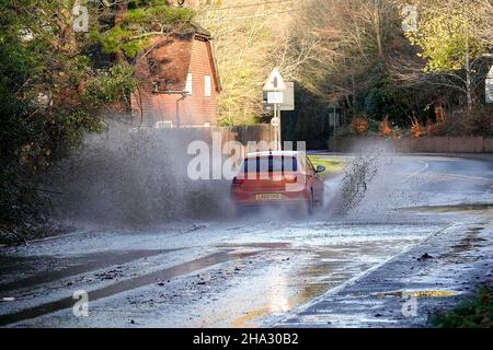 Station Lane, Godalming. 10th. Dezember 2021. Starke Regenfälle über Nacht verursachten Probleme mit Oberflächenüberflutungen in den Heimatkreisen. Fahrzeuge, die durch das Hochwasser in Godalming in Surrey fahren. Kredit: james jagger/Alamy Live Nachrichten Stockfoto